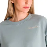 Buzo celeste de corte cropped con cuello redondo y mangas largas. Tiene el logo de la marca bordado en el frente.