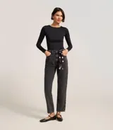 Pantalón mom de jeans con lavado oscuro, con trabillas en la cintura y pañuelo estampado de lunares atado como cinturón.