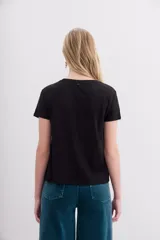 Remera de mangas cortas color crudo, de calce relajado y escote redondo. El frente se encuentra bordado con un diseño de palmeras en lentejuelas y canutillos.