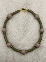 Collar corto con cuentas redondas color lila y cuentas cilíndricas color verde oliva, separadas por anillos dorados.