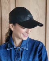 Gorra tipo béisbol color marrón, confeccionada en cuero gamuzado.