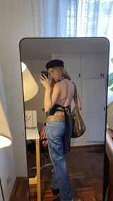 Top negro con escote halter y espalda descubierta con tiras ajustables.