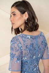 Vestido largo de tul bordado color azul jean, de corte recto, con escote en V y mangas cortas.