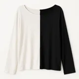 Blusa de mangas largas, amplia y holgada, con escote en V y diseño color block blanco y negro.