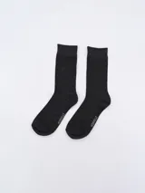 Par de medias de caña media color gris oscuro con textura tejida en rombos pequeños. Marca Mirarelli visible en la planta del pie.