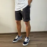 Bermuda color beige de gabardina, con bolsillos laterales y traseros.