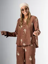 Conjunto de camisa y pantalón marrón chocolate con bordados en hilo crudo. El pantalón lleva elástico en la cintura.