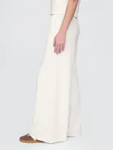 Pantalón deportivo de mujer color blanco hueso, de corte ancho y tiro alto.