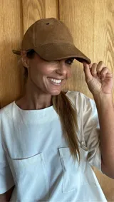 Gorra tipo béisbol color marrón, confeccionada en cuero gamuzado.