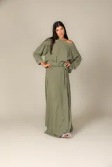 Blusa verde oliva de gasa con mangas largas abullonadas y escote barco. Tiene un lazo a la cintura para ajustar.