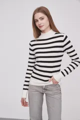 Polera de rayas en blanco y negro, ajustada al cuerpo, con manga larga y cuello alto.