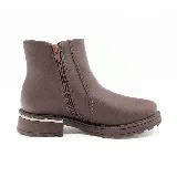 Bota corta marrón de cuero sintético, con elástico lateral y detalle de pespuntes en forma de rombos. Tiene suela track y un aplique metálico plateado en el talón.