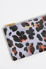 Monedero Bimba y Lola con estampado animal print en tonos lila, negro y naranja. Cierre con cremallera dorada y logo de la marca en dorado.
