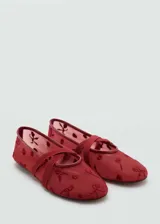 Zapato tipo bailarina color rojo con tejido de malla bordado con flores y tiras cruzadas.