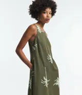 Vestido corto sin mangas color verde oliva con estampado de palmeras blancas.