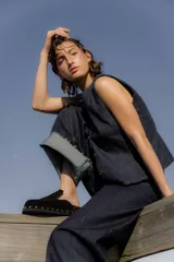 Zuecos de gamuza color marrón chocolate, con base de goma negra, tachas plateadas alrededor de la base y plantilla acolchada.