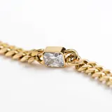 Pulsera dorada con eslabones y un cristal claro en el centro, de diseño elegante y sofisticado.