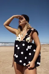 Bolso tipo tote bag de lona color crudo con estampado de lunares negros. Posee dos asas de hombro y una etiqueta blanca con el logo "AIRE" en el centro.