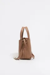 Bolso de mano Bimba y Lola modelo Chihuahua, tamaño mini, color marrón topo, fabricado en piel con piezas de metal plateado. Presenta estructura blanda, cierre con cinta de piel, logo metálico, bolsillo interior con cremallera e interior con logo grabado.