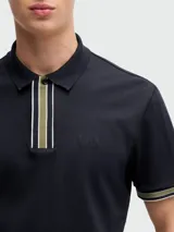 Polo de piqué de algodón color azul marino, corte regular fit, con cuello clásico, tapeta de dos botones con rayas en blanco y verde, mangas cortas con ribete a rayas y logo bordado en el pecho.