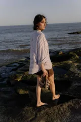 Sandalias tipo mule de cuero color marrón chocolate, con diseño de tiras anchas cruzadas y suela plana.