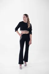 Top corto negro de mangas 3/4 con detalle de flecos de strass en el ruedo.