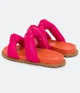 Sandalias planas con tiras puffa con nudo, color fucsia y suela naranja.