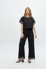 Blusa color crudo de lino y algodón, de manga corta con escote redondo y bordado de lentejuelas y mostacillas en el cuello y mangas.