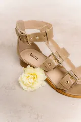 Sandalias bajas de cuero color marrón con múltiples tiras y hebillas metálicas ajustables.