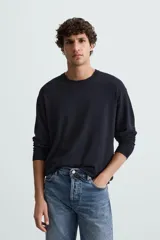 Jersey color topo de corte amplio, tejido en hilatura con mezcla de viscosa. Tiene cuello redondo, manga larga y terminaciones en rib.