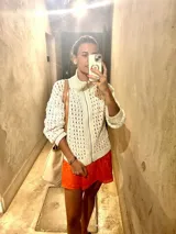 Campera color crudo tejida a crochet en algodón, con cuello alto y cierre frontal con cremallera.