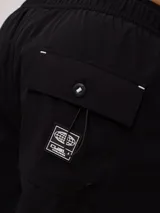 Short de baño negro con logo de la marca Rusty estampado en blanco en la pierna derecha.