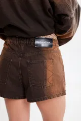 Short de jean azul con cintura elástica y cordón blanco con letras rojas.