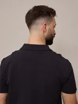 Chomba azul marino de piqué de algodón con cuello clásico y tapeta de dos botones. Logo bordado en el pecho. Corte clásico.