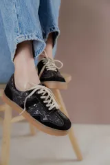 Championes acordonados color beige y dorado con suela marrón.