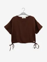 Remera marrón de mangas cortas con cordones ajustables en el ruedo.