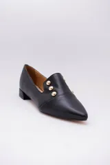 Chatitas negras de cuero con punta fina y apliques de tachas doradas.