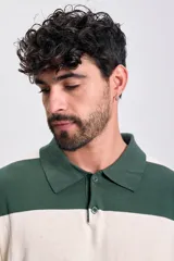 Buzo de tejido de punto con cuello polo y cierre parcial de botones. Presenta un diseño de rayas horizontales anchas en color verde oscuro y blanco crema.