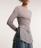 Blusa de viscosa color gris con efecto gastado, cuello redondo, mangas largas, fruncido lateral y abertura.