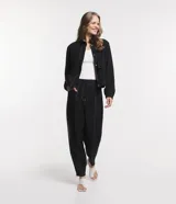 Campera bomber negra de viscosa con cierre delantero, bolsillos con solapa y pespuntes contrastantes en color blanco.