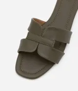 Sandalia plana de cuero sintético color negro, con puntera cuadrada y tiras anchas en forma de H.