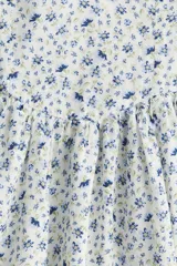 Vestido corto de algodón con estampado floral en tonos azules y amarillos. Tiene escote en pico, breteles anchos fruncidos y cuerpo entallado con costura fruncida en la cintura y falda con vuelo.