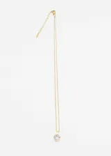 Cadena dorada de acero quirúrgico con dije circular con una piedra blanca rodeada de pequeñas circonitas.