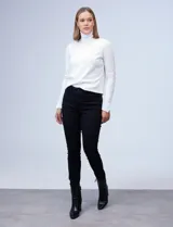 Jean skinny elastizado negro de tiro alto, con pretina, botón y cierre, además de bolsillos delanteros y traseros.