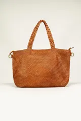 Bolso de mano tipo tote bag color marrón, confeccionado en cuero trenzado. Tiene doble asa corta trenzada y herrajes metálicos dorados.