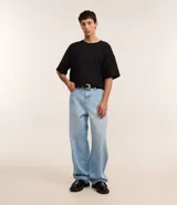 Pantalón de jeans celeste con textura, corte super baggy, cintura con trabillas, cierre tradicional y bolsillos.