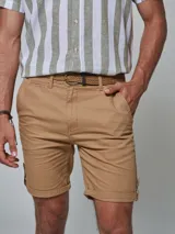 Bermuda color beige con cinturón, corte regular fit, dos bolsillos delanteros, dos traseros, un bolsillo relojero y botamanga con presilla. Aplique de badana.