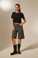 Bermuda de jean gris oscuro, tiro alto, corte holgado y recto, con apliques de strass plateados distribuidos por toda la prenda.