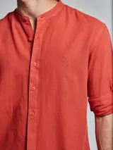 Camisa blanca de lino con cuello mao y mangas largas con presilla para enrollar.