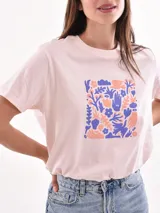 Remera color naranja con estampado de flores blancas.